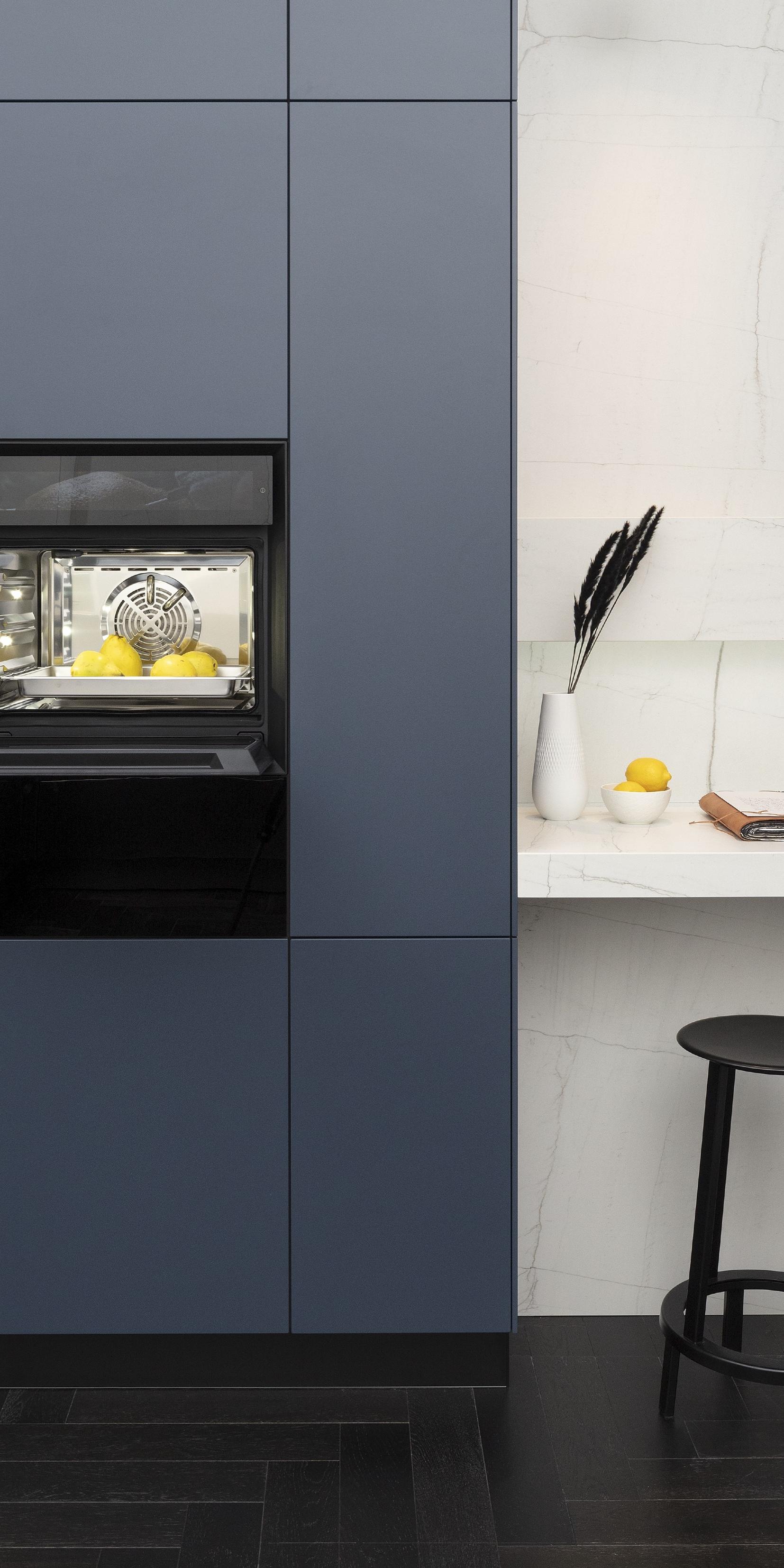 Front: Industriestahl Metalliclack geschliffen AV6000 NCS Mattlack APL: Franke Edelstahl 6 mm Geräte: Bora Spüle Armaturen: Franke  Features: Metallfront, Spülbecken in APL integriert (aus einem Guss), Oberschränke mit Lowboard-Charakter, integrierter Arbeitsplatz, dunkler Korpus mit Aluminium-Abschlussleiste, Wärmeschublade mit Gittereinsatz.