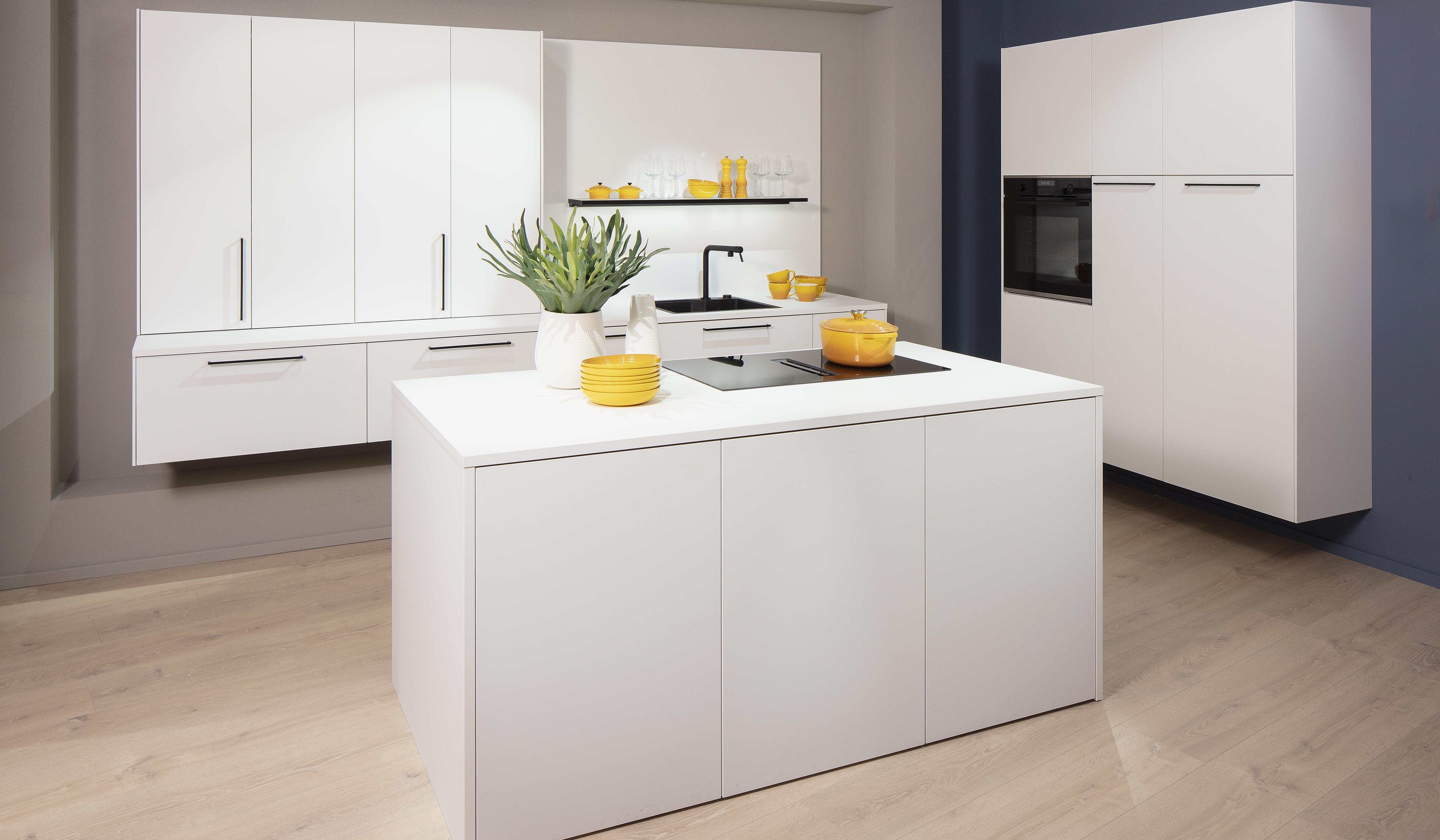 Häcker-Küche in Kristallweiß mit Insel und Schrankwänden. 